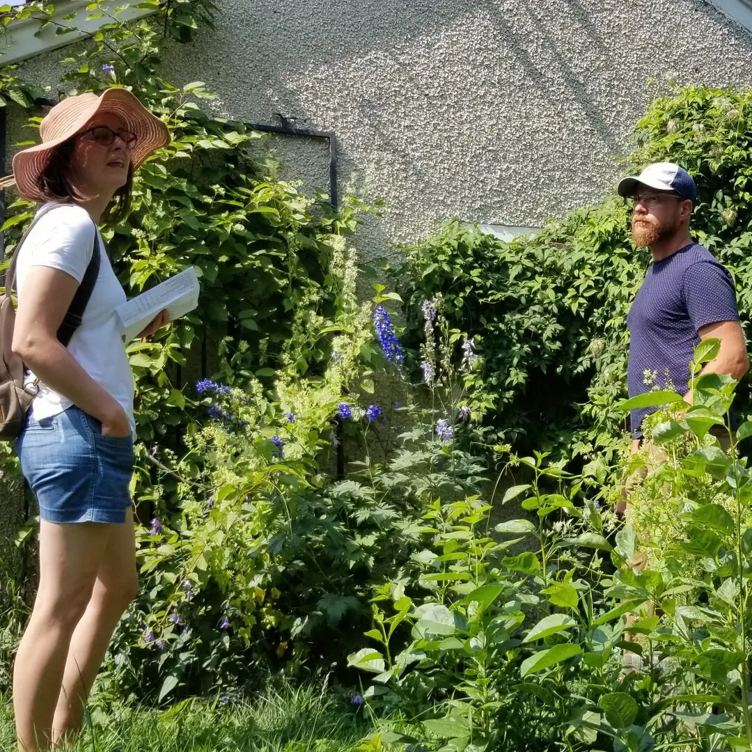 Young couple touring a backyard permaculture garden